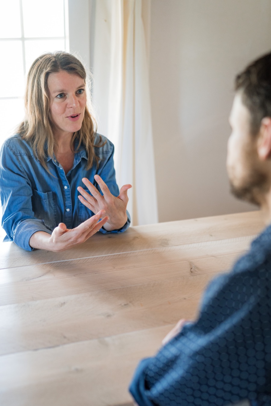 Flore legt iets uit met sprekende handen tijdens een trainingsgesprek